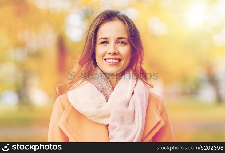 season, emotions, facial expression and people concept - beautiful happy young woman smiling in autumn park. beautiful happy young woman smiling in autumn park