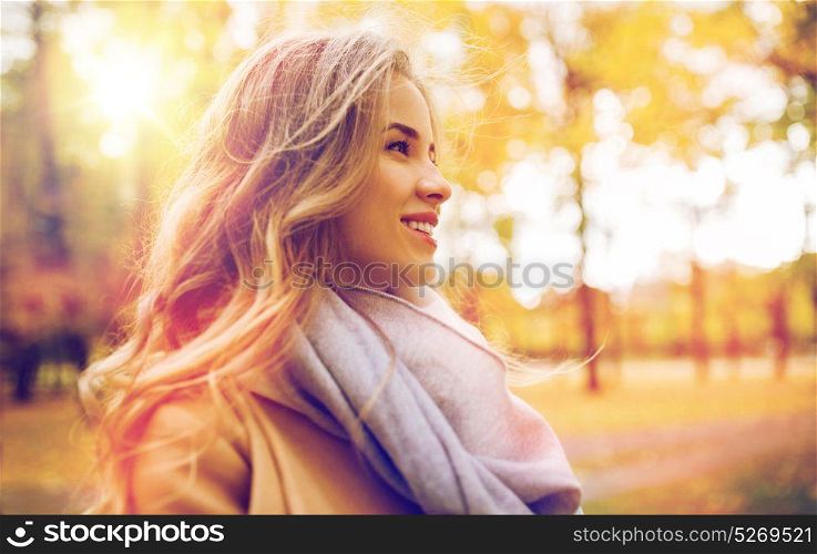 season, emotions, facial expression and people concept - beautiful happy young woman smiling in autumn park. beautiful happy young woman smiling in autumn park