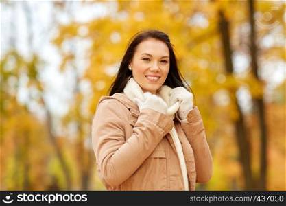 season, fashion and people concept - happy young woman smiling in autumn park. beautiful happy young woman smiling in autumn park