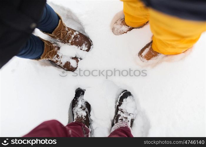 season, friendship and people concept - feet on snow