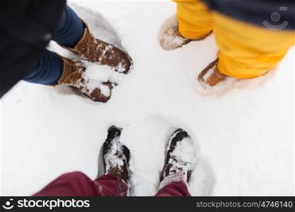 season, friendship and people concept - feet on snow