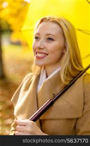 season, happiness and people concept - smiling woman with umbrella in autumn park