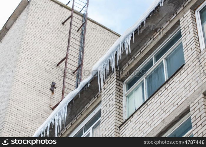 season, housing and winter concept - icicles on building or living house facade