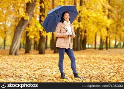 season, weather and people concept - beautiful happy young woman with umbrella in autumn park. happy woman with umbrella in autumn park