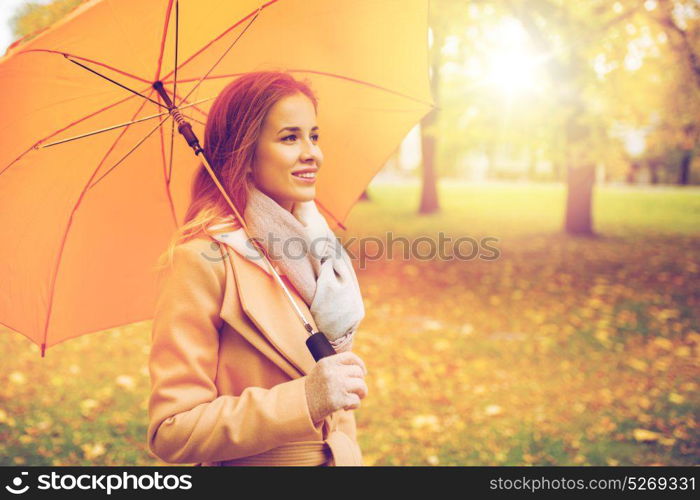 season, weather and people concept - beautiful happy young woman with yellow umbrella walking in autumn park. happy woman with umbrella walking in autumn park