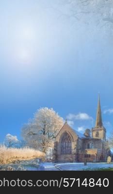 Seasonal background with snow covered trees and church.