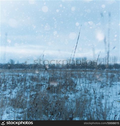 Seasonal backgrounds with snow covered field under moody skies