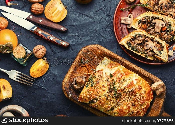 Seasonal closed homemade savory tart pie with mushrooms and persimmon. Tasty pie with mushrooms ch&ignons and persimmon
