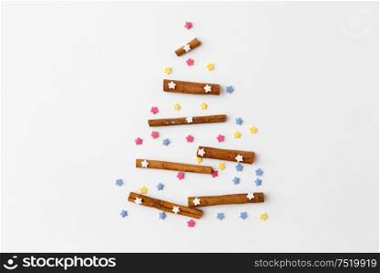 seasonal food, spices and sweets concept - christmas tree made of cinnamon sticks and sprinkles. christmas tree of cinnamon sticks and sprinkles