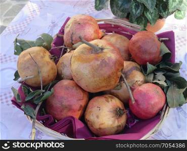 seasonal fruits of red and yellow pomegranate on basket
