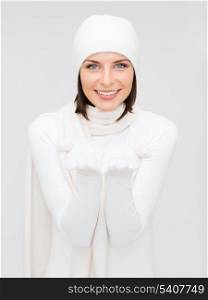 seasonal, people, happiness concept - smiling woman in winter clothes with something on palms