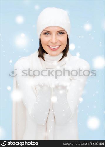 seasonal, people, happiness concept - smiling woman in winter clothes with something on palms