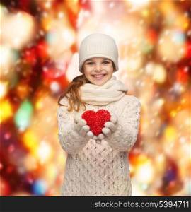 seasonal, people, happiness , health, charity, love concept - smiling teenage girl in winter clothes with small red heart