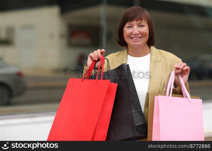 Seasonal Sales. Happy adult woman with shopping bags. Middle ages female after shopping on shopping mall background. Purchases, discounts, sale concept. Online shopping concept, Black friday. mockup.. Seasonal Sales. Happy adult woman with shopping bags. Middle ages female after shopping on shopping mall background. Purchases, discounts, sale concept. Online shopping concept, Black friday. mockup