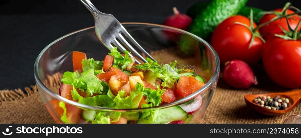 Seasonal summer vegetable salad in a glass bowl on a dark background. Vegan organic food, dietary meal in a rustic style. Banner format.. Seasonal summer vegetable salad in a glass bowl on dark background. Vegan organic food, dietary meal in a rustic style.