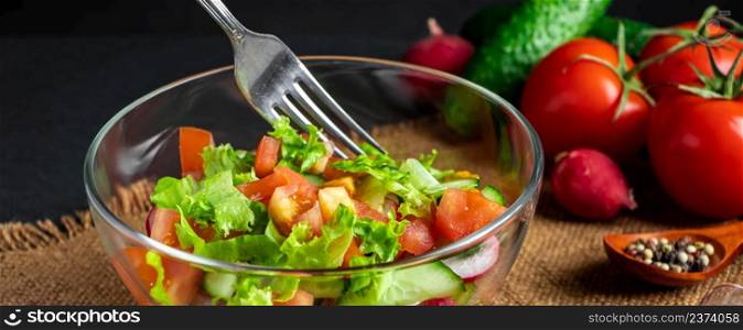 Seasonal summer vegetable salad in a glass bowl on a dark background. Vegan organic food, dietary meal in a rustic style. Banner format.. Seasonal summer vegetable salad in a glass bowl on dark background. Vegan organic food, dietary meal in a rustic style.