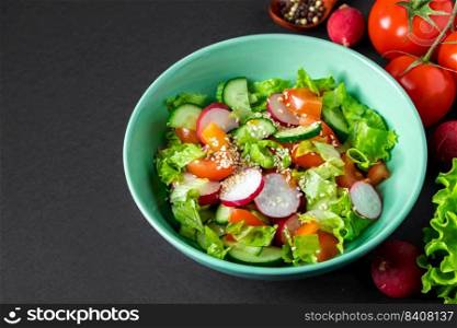 Seasonal vegetable salad from organic farm products on a gray background. Mix of tomatoes, cucumbers and radishes. Place for text.. Seasonal vegetable salad from organic farm products on gray background. Mix of tomatoes, cucumbers and radishes.