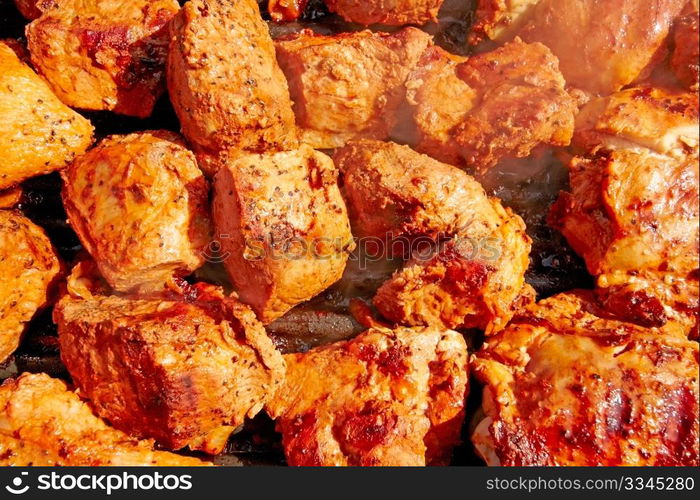 Seasoned chicken and meat shish kebobs are being prepared on the grill.