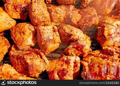 Seasoned chicken and meat shish kebobs are being prepared on the grill.