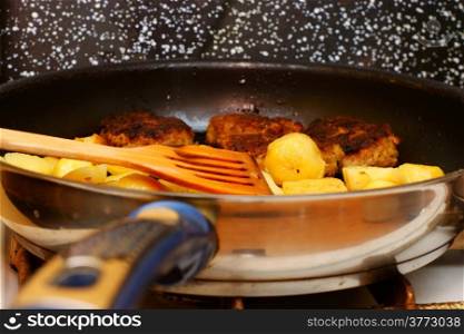 Seasoned potato slices in skillet pan in kitchen