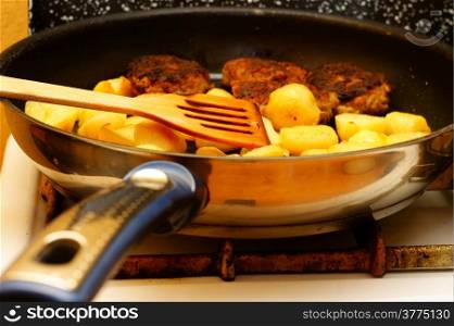 Seasoned potato slices in skillet pan in kitchen