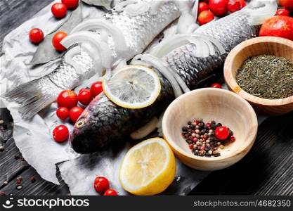 Seasoning for raw fish. Carcass raw fish on the kitchen table with spices
