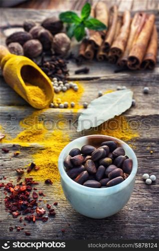 Seasoning with spices in wooden spoons on wooden table in rustic style.Pepper,cinnamon,cloves and mint