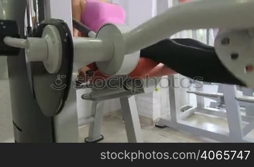 Seated leg extension machine exercise in health fitness club jib crane shot