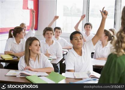 Secondary school students in a classroom answering questions