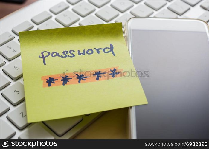 Secret password written on yellow paper note stick on blank black screen of mobile phone with modern white keyboard on background. E-commerce, internet banking, data privacy, cyber security concepts.