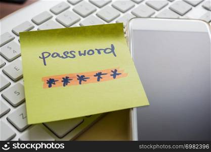 Secret password written on yellow paper note stick on blank black screen of mobile phone with modern white keyboard on background. E-commerce, internet banking, data privacy, cyber security concepts.
