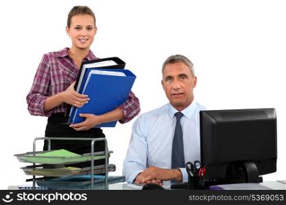 secretary bringing folders to her boss