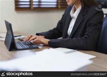 Secretary concept, Female secretary is working and typing report of business on tablet in office.