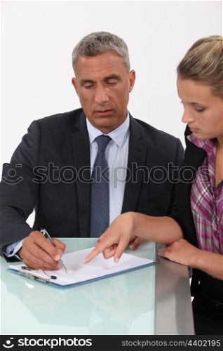 Secretary helping her boss fill in paperwork