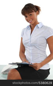 Secretary perched on a desk with a clipboard