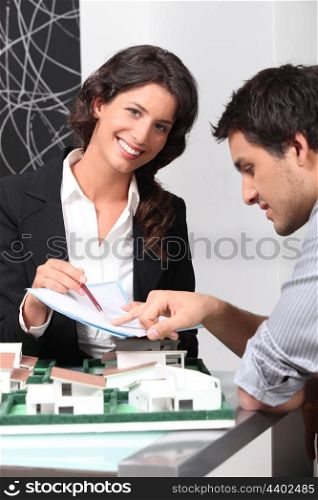 Secretary presenting an architect with a document to sign