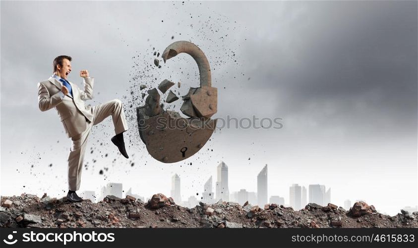 Security concept. Businessman breaking stone lock with karate kick