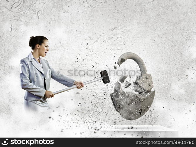 Security concept. Image of businesswoman crashing lock with hammer