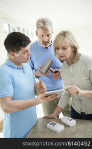 Security Consultant Demonstrating Alarm System To Mature Couple