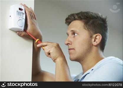 Security Consultant Fitting Burglar Alarm Sensor In Room