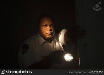 Security guard investigates with flashlight