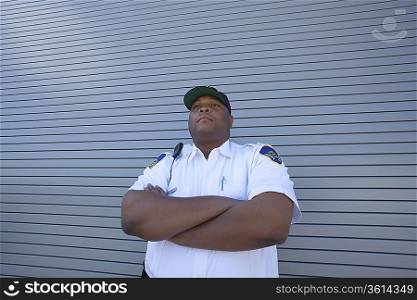 Security guard protects doorway with arms folded