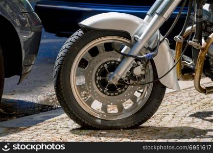 Security number padlock blocking motorcycle wheel on the street.
