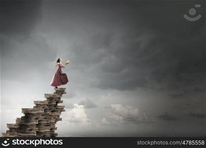 Seek for education and knowledge. Woman in long dress with book in hand