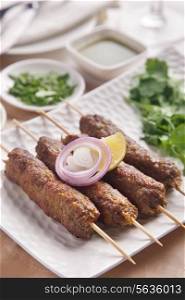 Seekh kabab garnished with onion and lime in plate