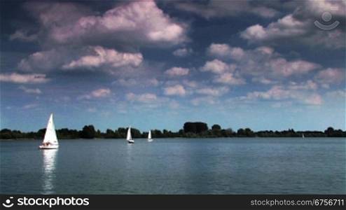 Segelboote fahren auf einem See am Tag mit wolkenbedecktem Himmel