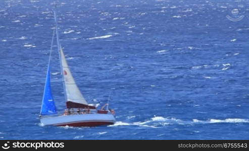 Segelyacht auf dem Meer bei starkem Seegang mit Personen an Bord