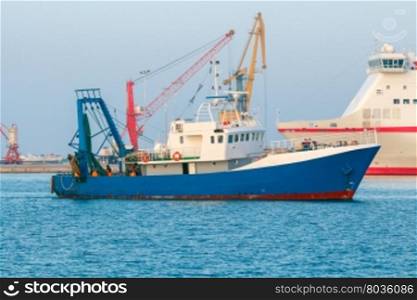 Seiner fishing in the bay.. Blue fishing boat enters the port of Heraklion.
