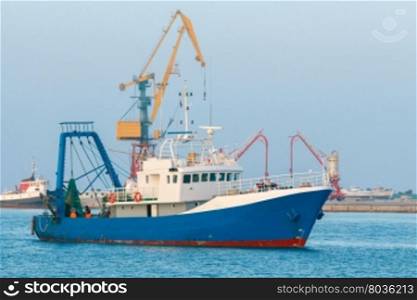 Seiner fishing in the bay.. Blue fishing boat enters the port of Heraklion.