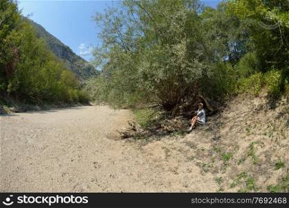 seinor male hiker relaxing in nature while  walking tour on beautiful summer day on canyon of  dried riverbed